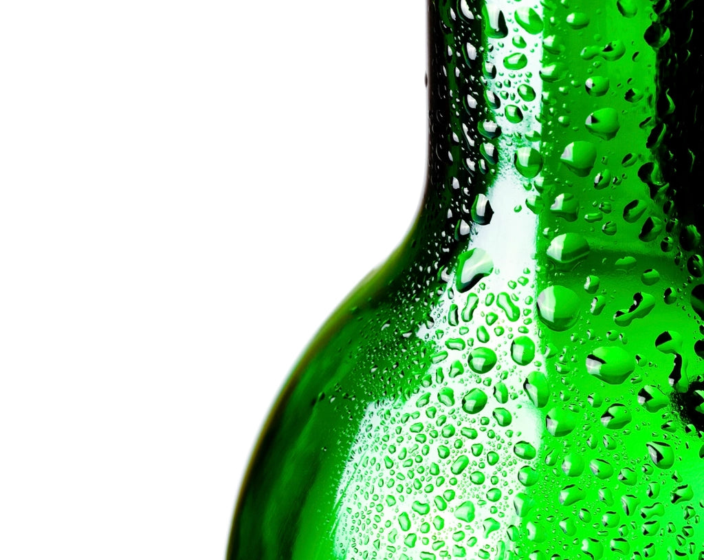 A green glass bottle beaded with condensation