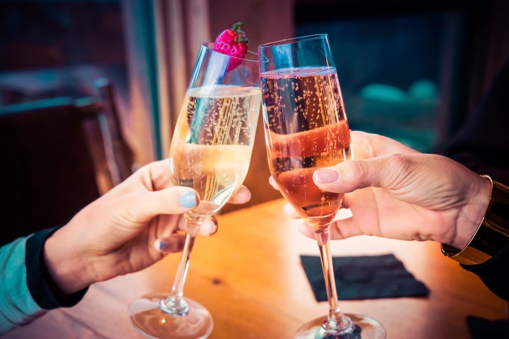 Fine glassware and sparkling drinks raised in a celebratory toast